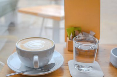 Cafe latte ile kalp latte sanat kafeterya masada büyük beyaz bardak
