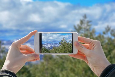 Telefon ve doğa vally iki elle fotoğrafı çekimi tutan kız