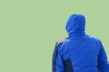 Adam oturmuş ve izole üzerinde yeşil pastel renk seyir jacked mavi