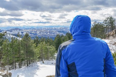 Adam oturmuş ve Vadisi ve çam ağacı orman üzerinde seyir jacked mavi