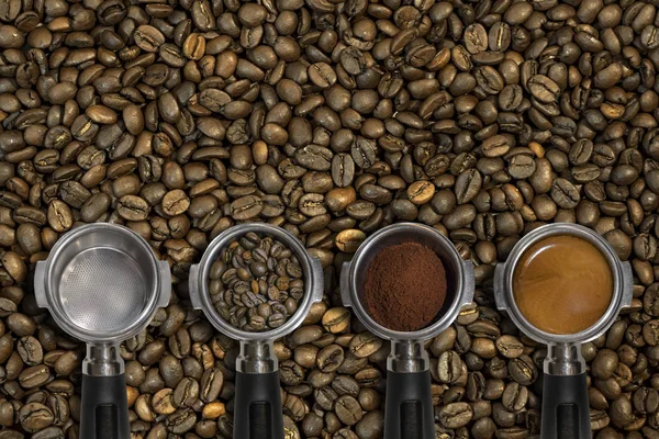 Metal espresso makinesi kepçe geçerken boş gelen dosyalanmış bir espresso ve fasulye arka plan ile