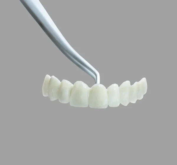 灰色の背景に分離されたクラッチの人工歯 — ストック写真
