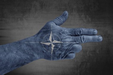 Erkek eli silah gibi boyanmış Nato bayrağı 