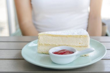 Kremalı pasta parçası puf vanila böreği plaka üzerinde ahşap masa