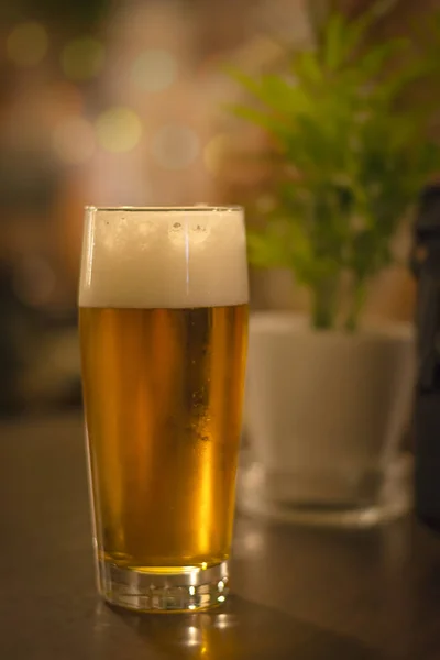 暗いパブでの軽いビールのグラス — ストック写真