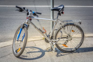 Sokaklarda bisikletle direğin yanında park edilmiş ve güvenli kilitleme aygıtı
