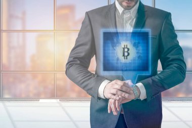 BITCOIN hologramını gösteren akıllı kasete basan iş adamı 