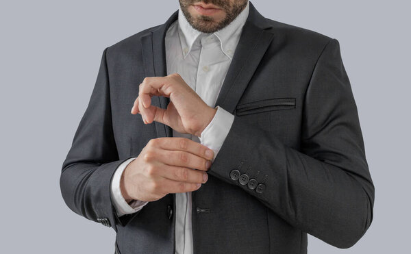 Groom buttons cuffs on the shirt close up isolated