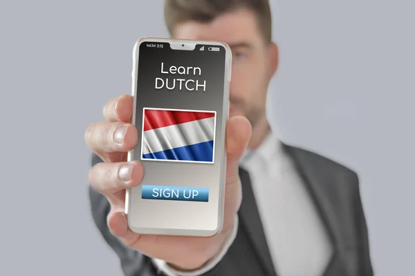 Online concept learn Dutch language with a person showing e-learning app on mobile phone with the flag of Netherlands isolated