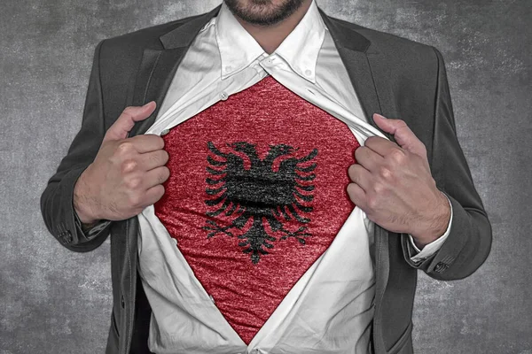 Business man rips open his shirt to show t-shirt with flag of Albania