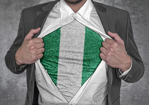 Business man show t-shirt flag of Nigeria rips open his shirt