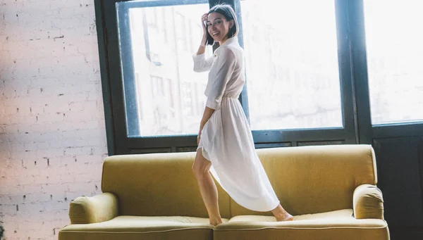 Chica sonriente en vestido blanco sobre el fondo blanco. Estilo de grano de película, aspecto cinematográfico —  Fotos de Stock