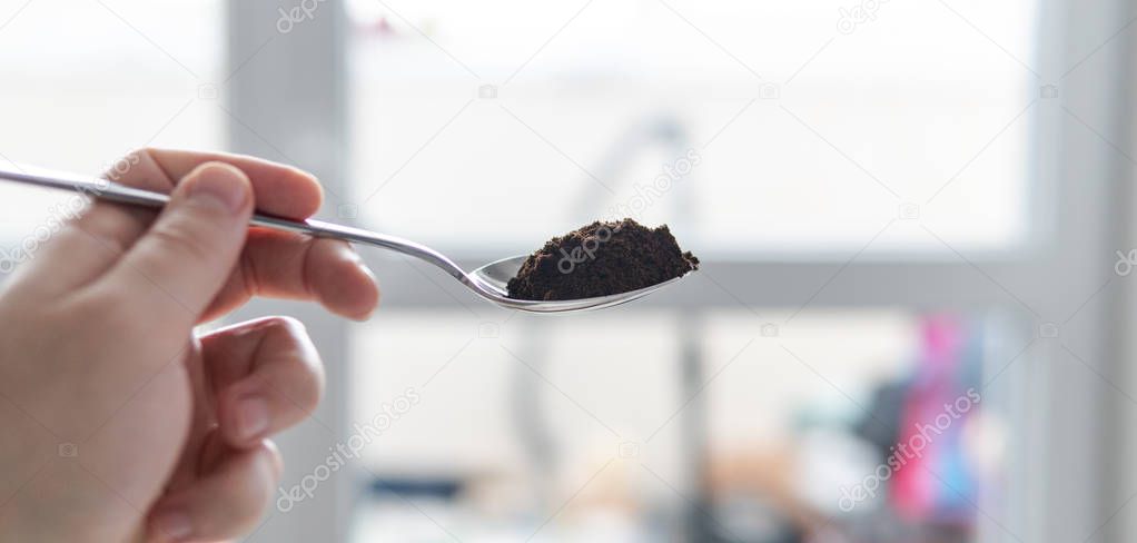 ground coffee in a tablespoon. Portion of coffee for cooking.