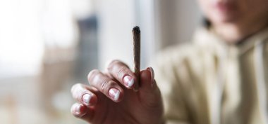 kadın vücudu üzerinde esrar etkisi. Kadın ellerde esrar ile sigara ortak 