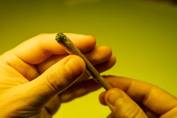 Brûlant joint avec marijuana dans tha mans mains gros plan . — Photo