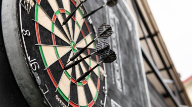 siyah bir arka plan üzerinde gözlük bir levha ile dart oynamak için alan. Dart ve dart skor bordroları