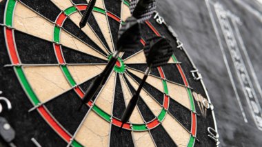 siyah bir arka plan üzerinde gözlük bir levha ile dart oynamak için alan. Dart ve dart skor bordroları
