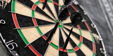 siyah bir arka plan üzerinde gözlük bir levha ile dart oynamak için alan. Dart ve dart skor bordroları