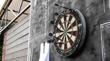 siyah bir arka plan üzerinde gözlük bir levha ile dart oynamak için alan. Dart ve dart skor bordroları