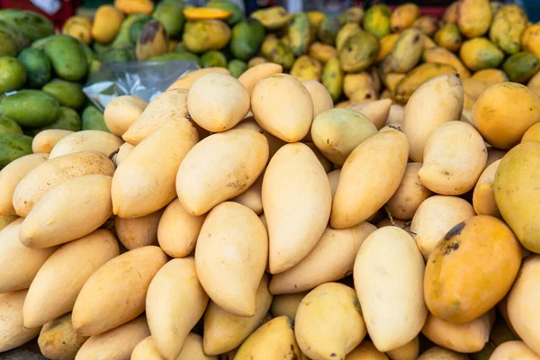 selling fresh mangoes in a market in Asia. Mango is the most popular fruit in Asia.