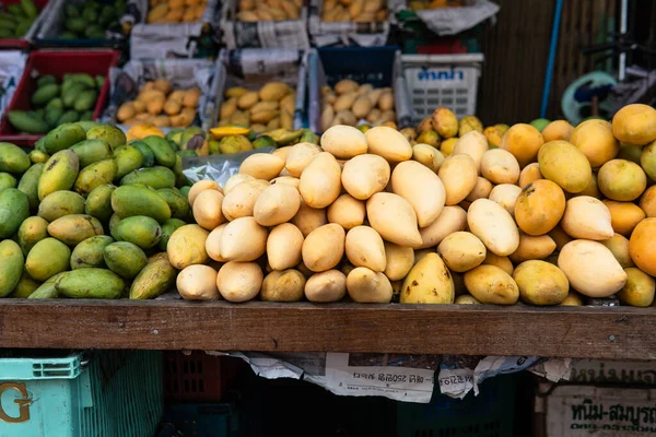 green mangoes lying on a market counter. Exotic fruits of Asia