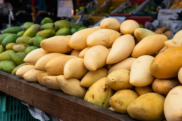 selling fresh mangoes in a market in Asia. Mango is the most popular fruit in Asia.