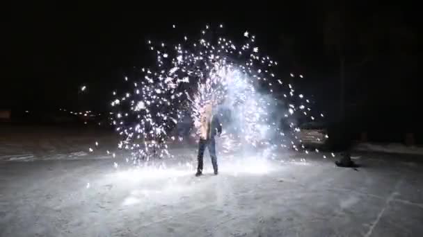 Amazing tribal fire show dance at night on winter under falling snow. Dance group performs with torch lights and pyrotechnics on snowy weather. — Stock Video