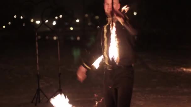 Úžasné taneční show rodového ohně v noci v zimě pod padajícím sněhem. Taneční skupina provádí s pochodeň světla a pyrotechniky na zasněžené počasí. — Stock video