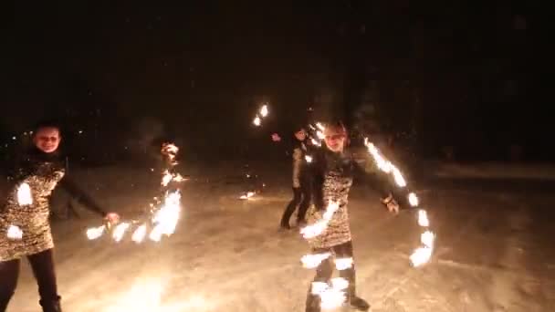 Espantoso show de fogo tribal dança à noite no inverno sob a neve caindo. Grupo de dança executa com luzes de tocha e pirotecnia em tempo nevado . — Vídeo de Stock