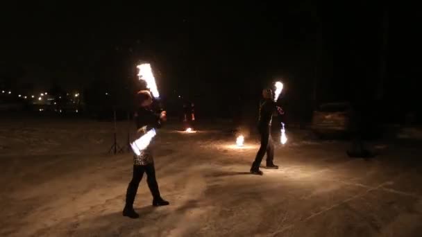 Espantoso show de fogo tribal dança à noite no inverno sob a neve caindo. Grupo de dança executa com luzes de tocha e pirotecnia em tempo nevado . — Vídeo de Stock