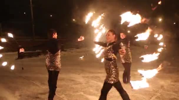 Increíble espectáculo de fuego tribal danza en la noche en invierno bajo la nieve que cae. Grupo de baile realiza con luces de antorcha y pirotecnia en clima nevado . — Vídeos de Stock