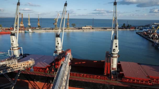 Timelapse of ship loading grain crops on bulk freighter via trunk to open cargo holds at silo terminal in seaport. Cereals bulk transshipment to vessel. Transportation of agricultural products. — Stock Video