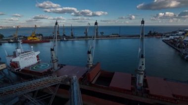 Timelapse geminin kargo açılış tahıl terminal bitkileri yük gemisi üzerinde yükleme için liman içinde tutar. Hububat gemisine aktarma toplu. Nakliye tarım ürünleri için. Gökyüzünde bulutlar float.