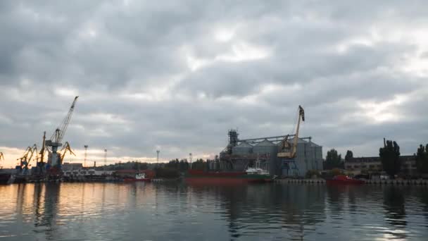 Day to night timelapse of epic skyline and floating clouds above seaport with cranes and big grain terminal in the evening. Agricultural bulk transshipment. Loading grain on ship from silo elevators. — Stock Video