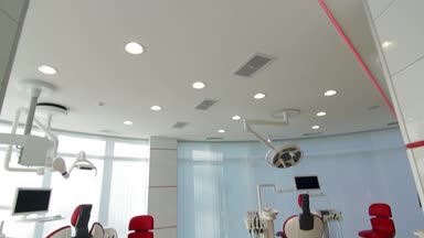Beyaz diş hekimi ofisi. Lüks minimalist diş kliniği iç cam duvarlar üzerinde diş lamba kırmızı sandalye ve araçları. Ameliyat odası modern donatımın tam çalışma diş hekimliği. Yavaş yavaş hareketli kamera