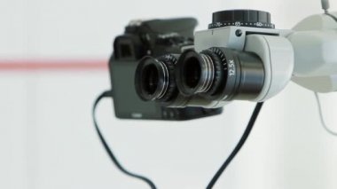 Beyaz diş hekimi ofisi. Lüks minimalist diş kliniği iç mikroskop, kamera ve dürbün vizör tanı için. Ameliyat odası modern donatımın tam çalışma diş hekimliği. Fotoğraf makinesi