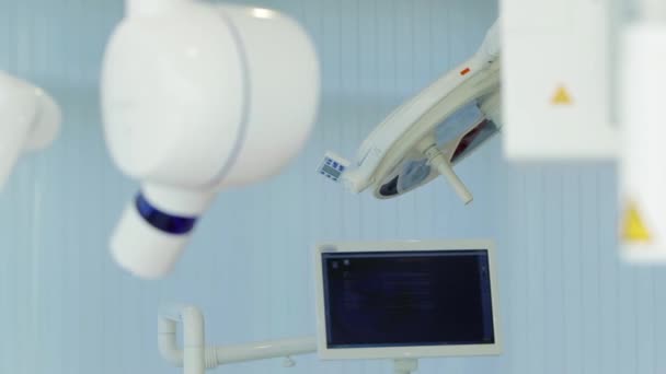 Cabinet de dentiste blanc. Luxe intérieur minimaliste clinique dentaire avec chaise rouge et des outils, lampe dentaire sur les murs de verre. La salle d'opération de la dentisterie est pleine d'équipement moderne. Caméra se déplace lentement — Video