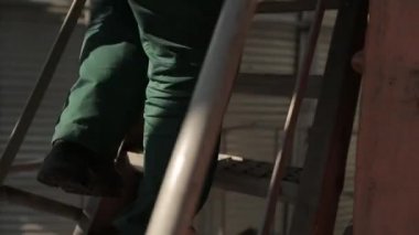 10 Eylül, 2016, Mariupol, Ukraine, Ukrtransagro Llc. işçi deniz tahıl terminal silo, merdivenlerden yukarı gider. Bulker gemi iskeledeki hareketli gövde makine üzerinden silo Tahıl yükleme bakan adam.