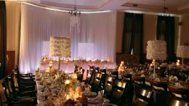 Düğün Ziyafet salonu iç detaylarla dekore edilmiş Sofra Restoran. Mumlar ve beyaz yaprakları dekorasyon cam vazo gül çiçeklerle su.