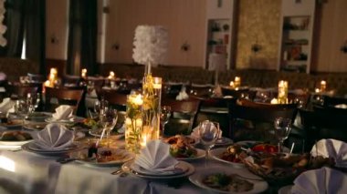 Düğün Ziyafet salonu iç detaylarla dekore edilmiş Sofra Restoran. Mumlar ve beyaz yaprakları dekorasyon cam vazo gül çiçeklerle su.