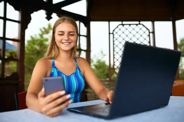Freelancer woman sitting at garden house in tropical summer location and working with laptop remotely in swimsuit. Traveling Thailand with a computer and wi-fi internet. Telecommuting concept — Stock Photo, Image