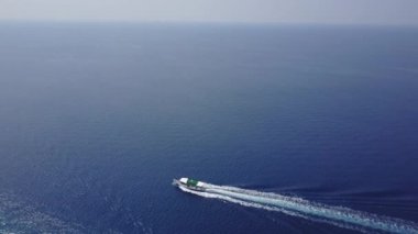 Havadan görüntüleri üstten görünüm ile yüksek hızda motorlu tekne dalgalar keser süre uzun beyaz bir iz bırakarak. Turizm için kavramsal video sunumu. Pahalı yaşam tarzı ve eğlence tür