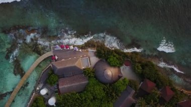 Üstten görünüm Maldivler Island, lüks tropikal otel resort barda aşağı cameragoes. Büyük sörf ve büyük dalgalar yukarıda gösterilen restraunt üzerinde azalan dron. Dalgalı hava fooage