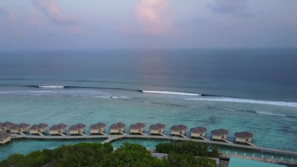 Vista aérea do hotel resort ilha tropical com bungalows e ondas turquesa oceano Índico em Maldivas em 4k — Vídeo de Stock