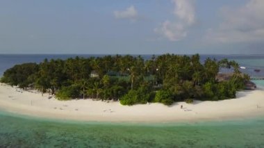Kameranın küçük yuvarlak tropikal atoll Island resort hotel beyaz kum palmiye ağaçları ve turkuaz Hint Okyanusu ile çevresinde Maldivler, dron görüntüleri havadan görünümü yukarıdaki 4 k uçar