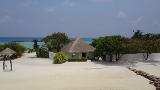 Vista aerea di bungalow spa sull'isola tropicale resort hotel con spiaggia di sabbia bianca, palme e l'oceano indiano turchese sulle Maldive in 4k. Drone fotocamera si avvicina bungalow casa . — Video Stock