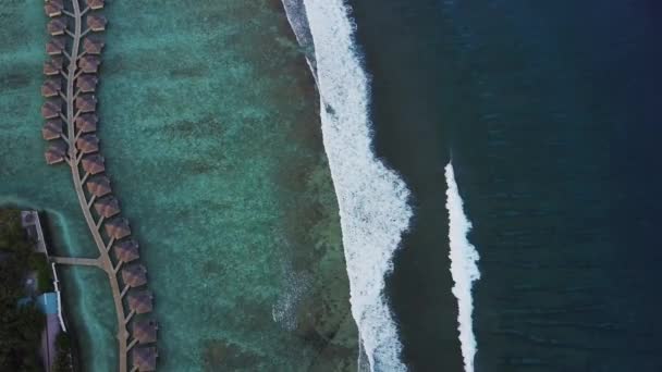 Luchtfoto van tropisch eiland resorthotel met bungalows en turkooizen Indische oceaan golven op Malediven — Stockvideo