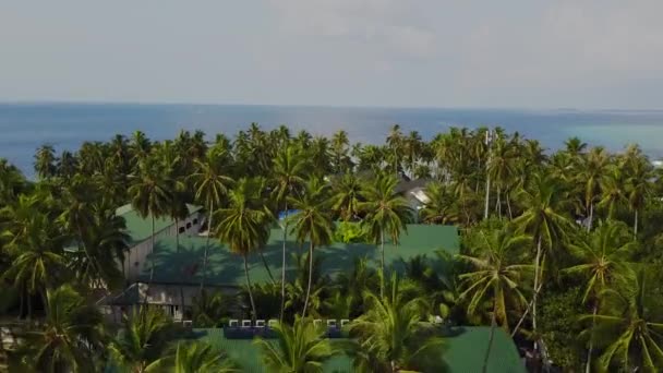 La telecamera sta sorvolando rotondo hotel resort isola atollo tropicale con palme di sabbia bianca e l'oceano indiano turchese sulle Maldive, drone vista aerea vista dall'alto in 4k — Video Stock