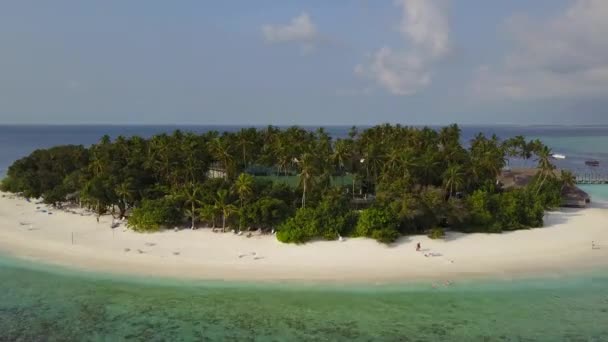 La cámara vuela alrededor del pequeño hotel turístico de isla atolón tropical redondo con palmeras de arena blanca y océano Índico turquesa en Maldivas, imágenes de aviones no tripulados vista aérea desde arriba en 4k — Vídeo de stock