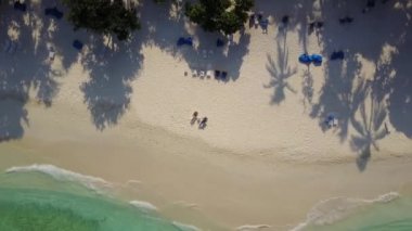 Hava dron kamera artan ve yüksek yukarıda da plaj yatak şezlong üzerinde güneşte yalan ve boş tropikal white adlı kokteyl içme aşık çift döner atoll Island resort ile sahilde kum